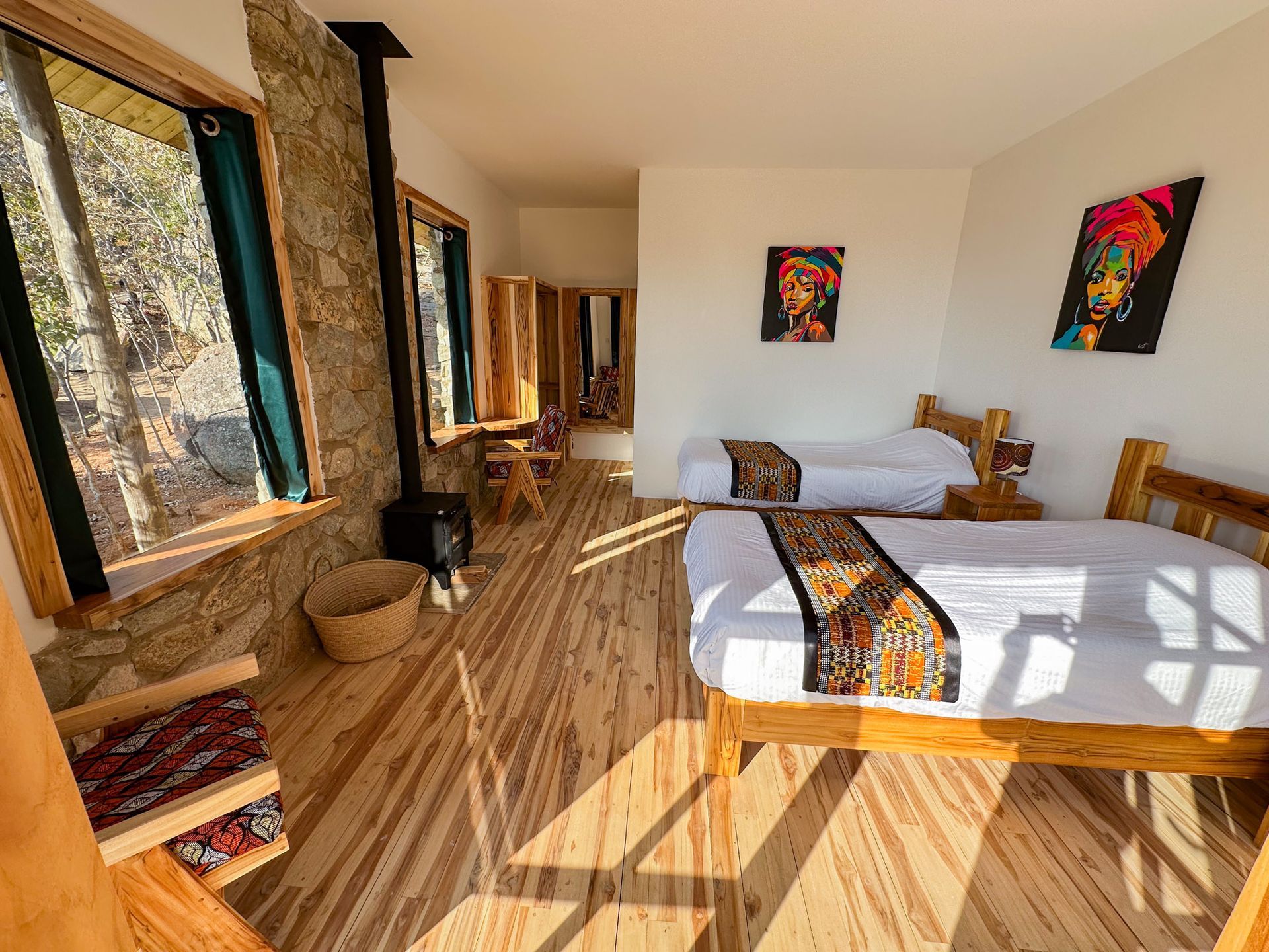 Aerial view of a white mansion surrounded by green fields and trees under a cloudy blue sky.
