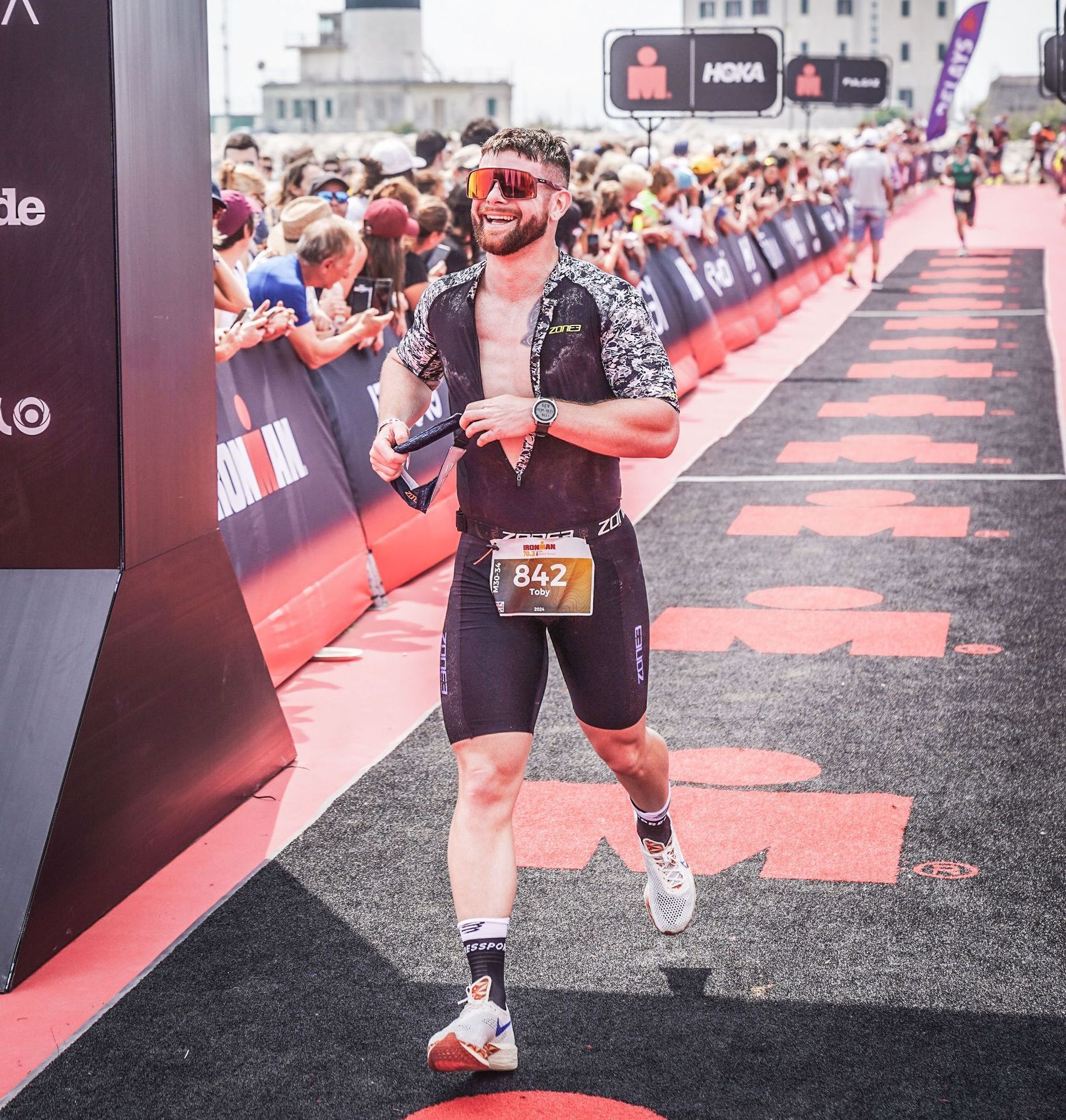 A man wearing sunglasses and a bib with the number 642 on it