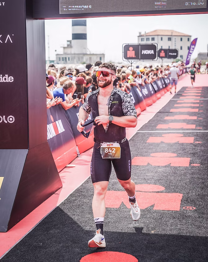 A man is running in a race with the number 352 on his bib