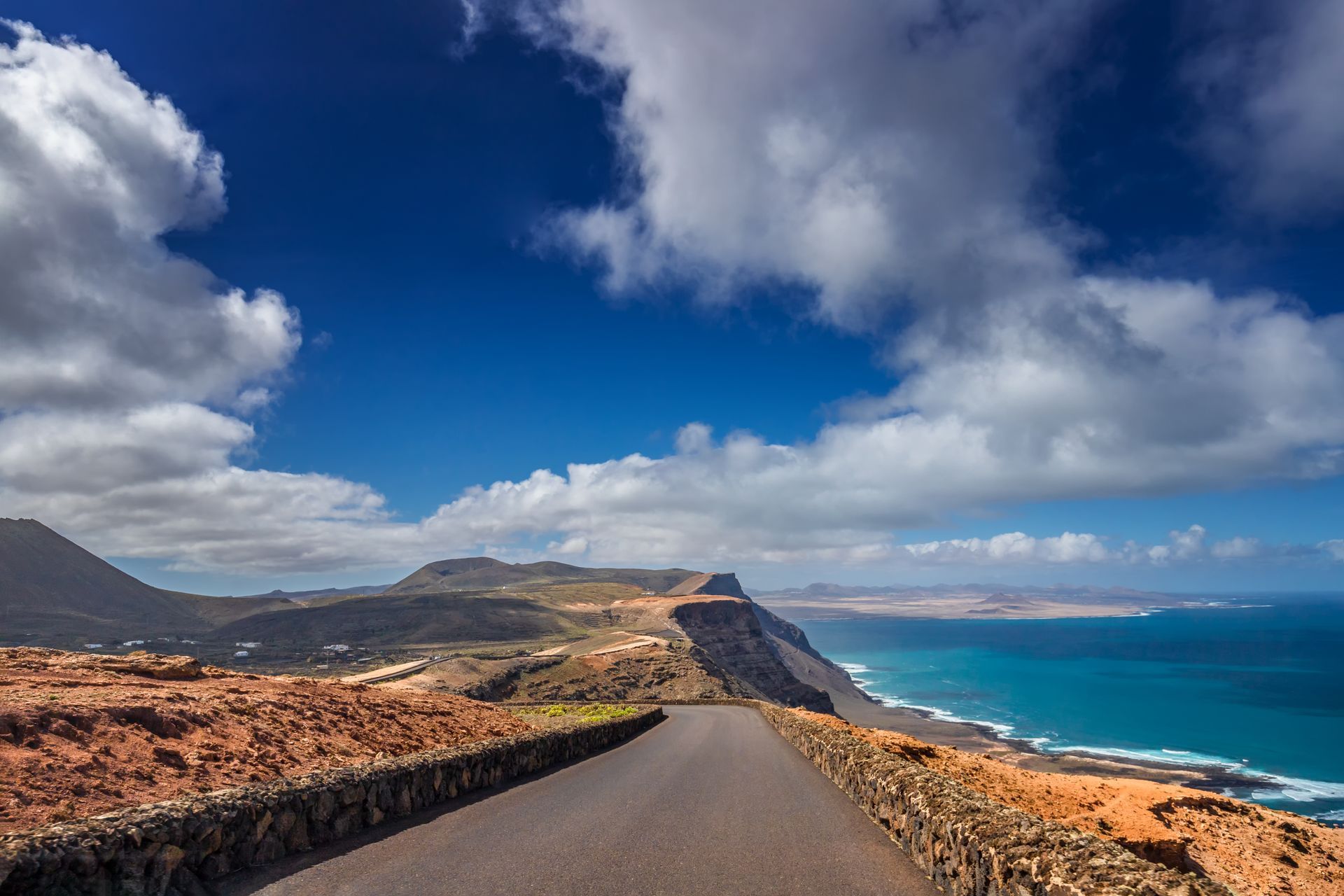 A road leading to the ocean on a cloudy day.