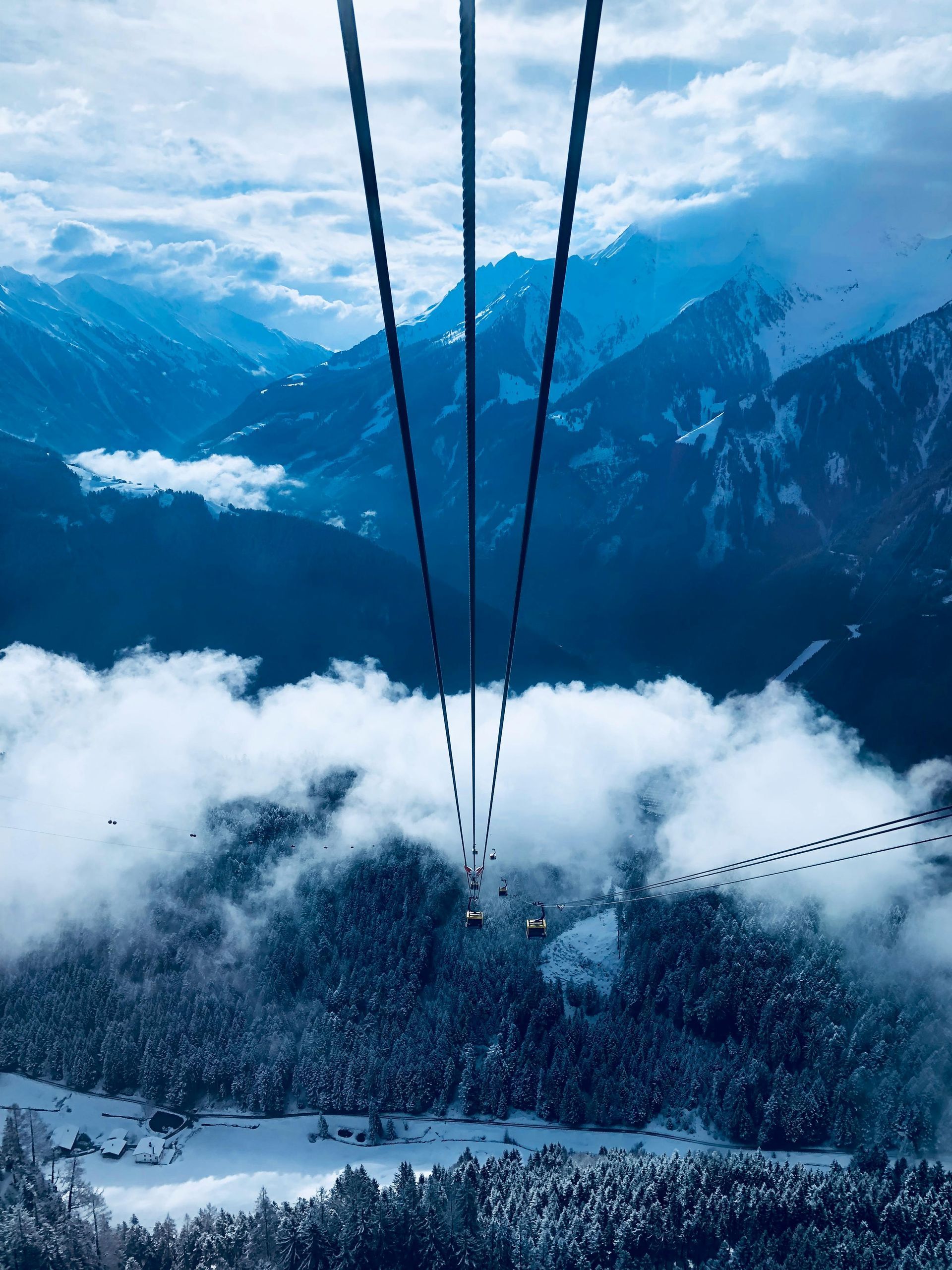 A ski lift is going up a snow covered mountain.