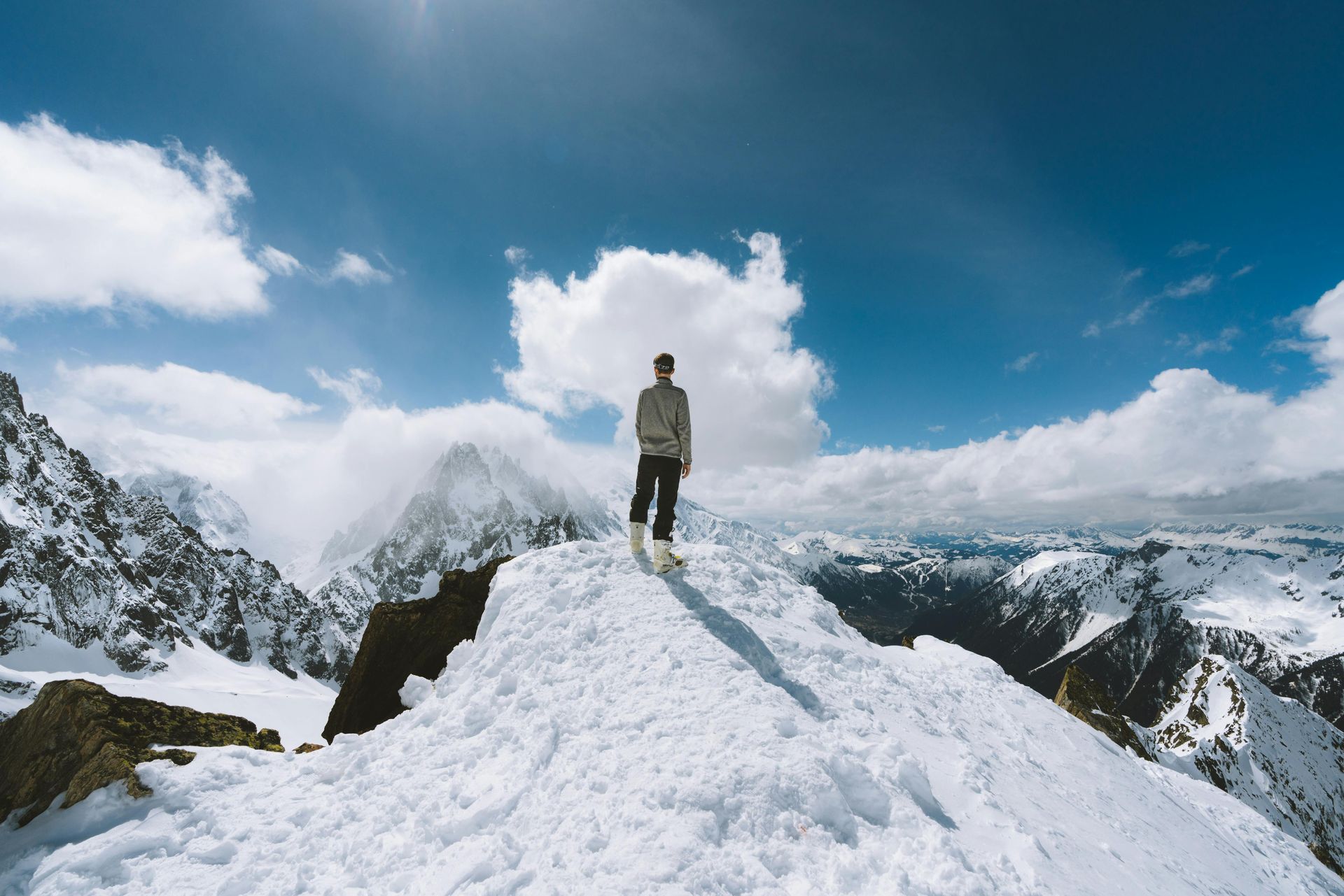 A man is standing on top of a snow covered mountain.