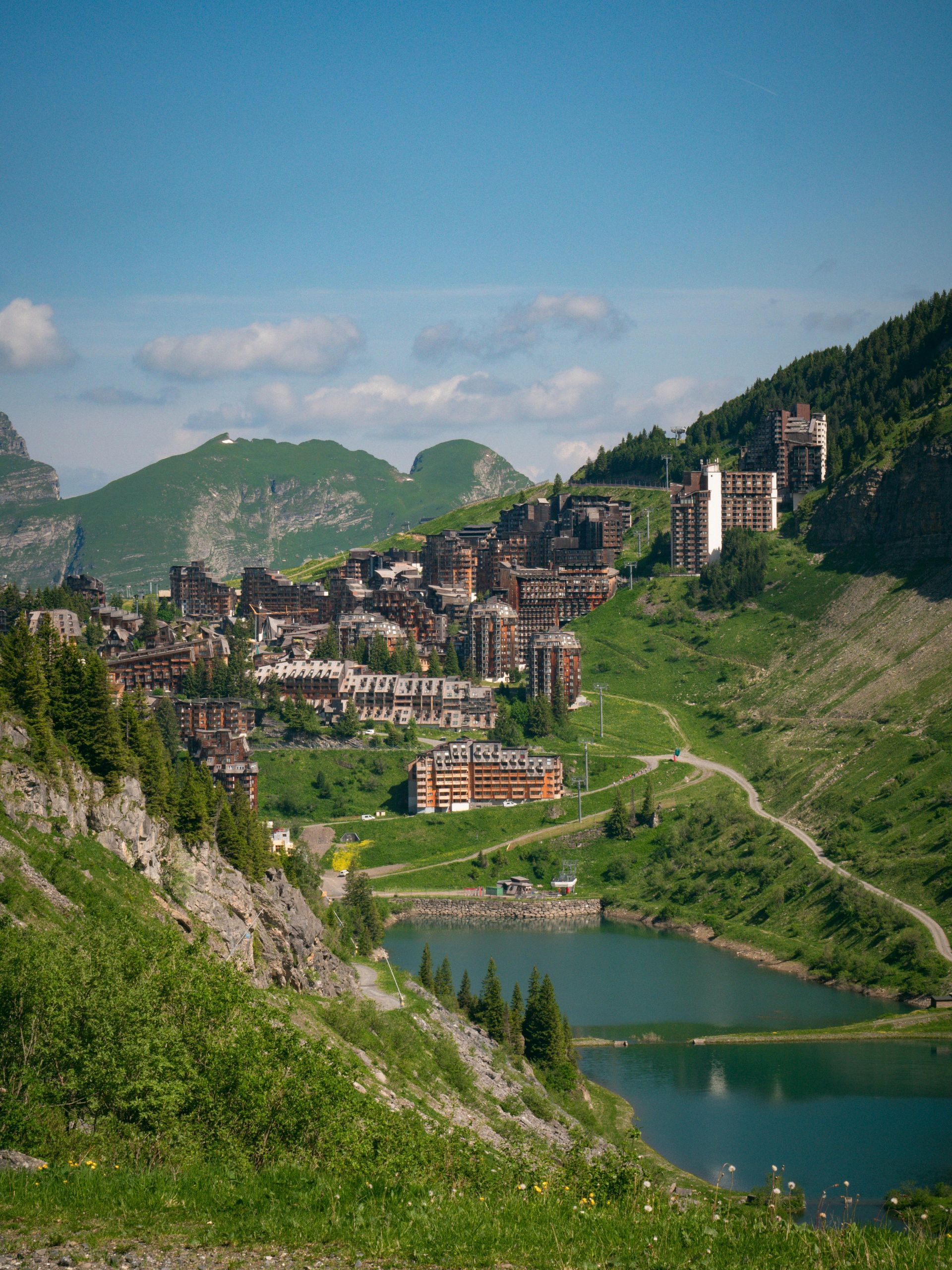 A small town is surrounded by mountains and a lake.