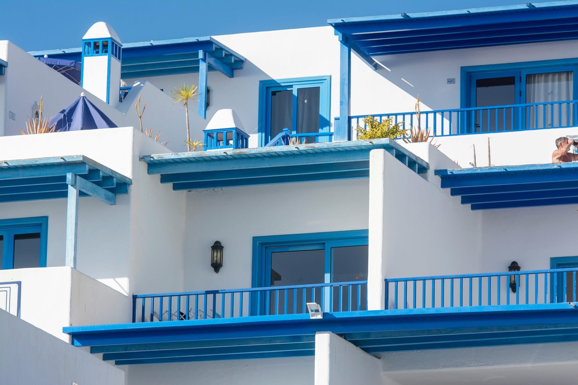 A white building with blue windows and balconies