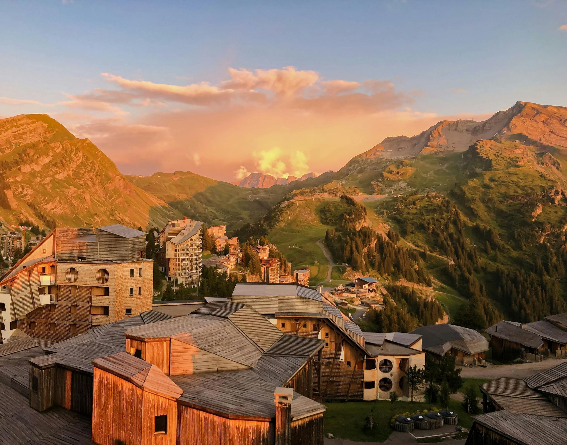 An aerial view of a village in the mountains at sunset.