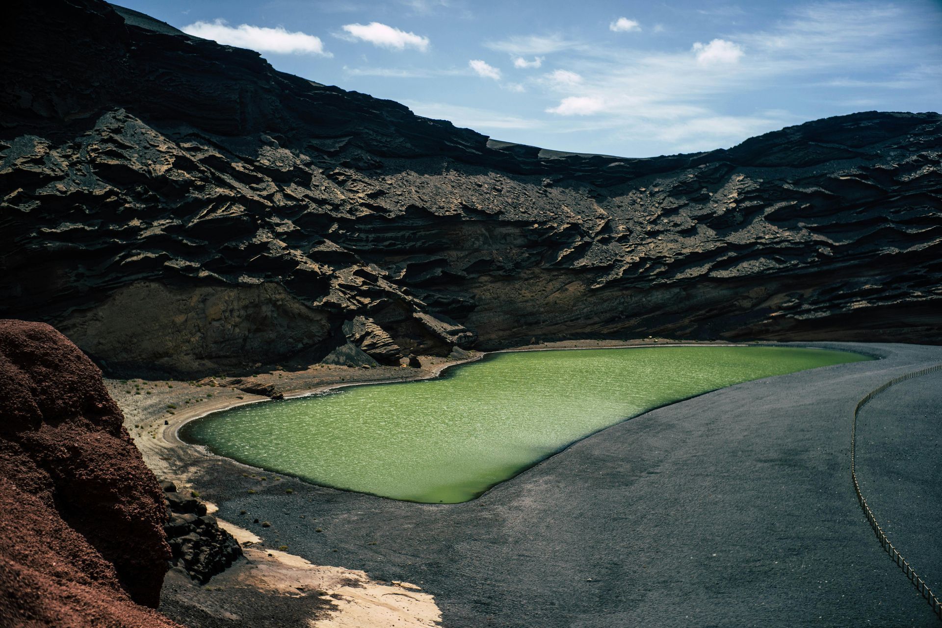 A small pond in the middle of a desert surrounded by mountains
