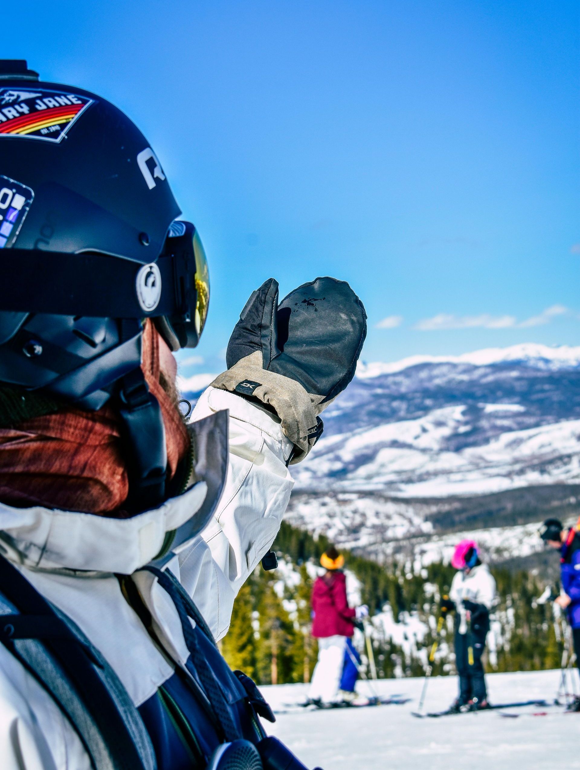 A person wearing a helmet and goggles is standing on a snowy mountain
