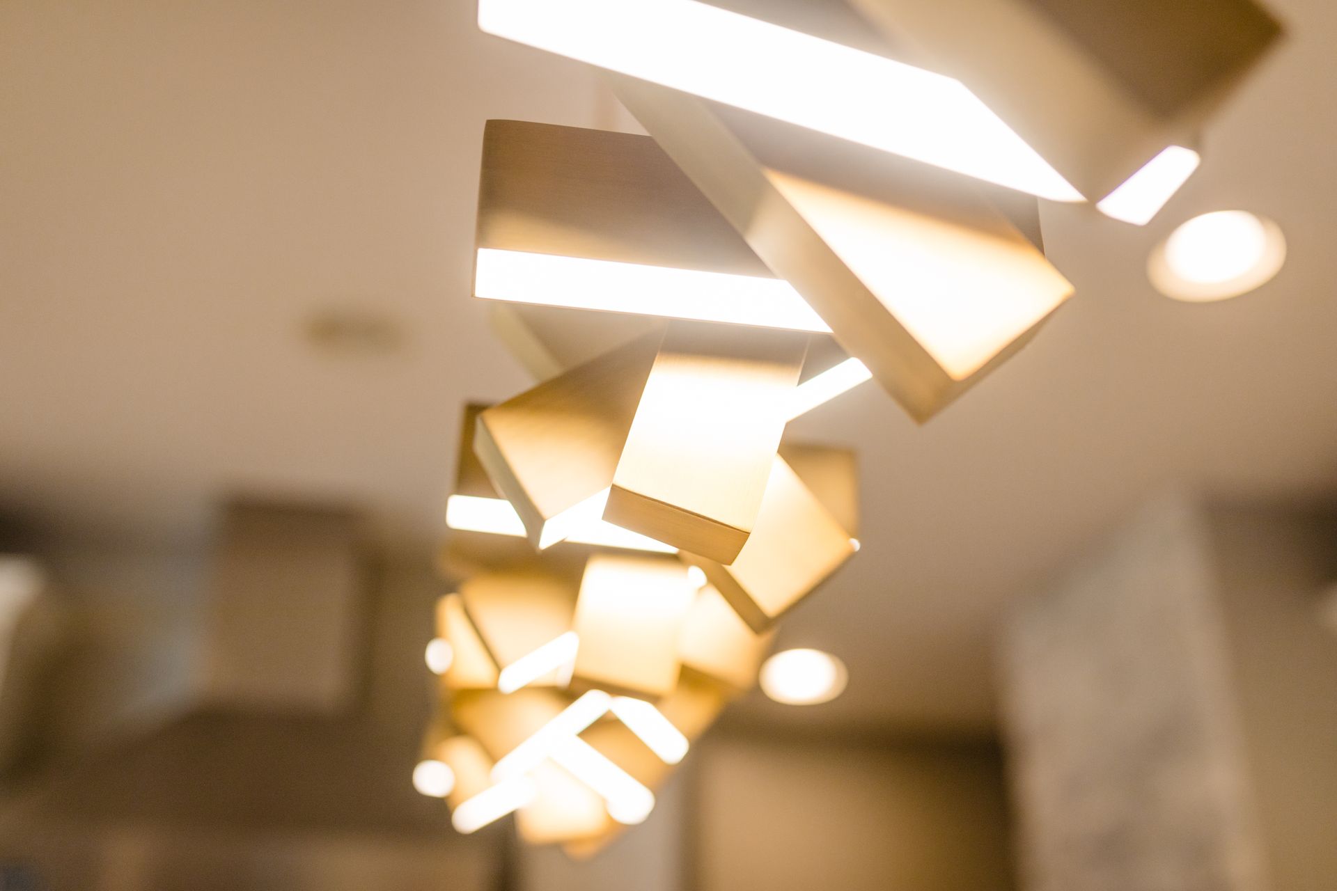 A kitchen with a stove top oven , cabinets , pendant lights and a window.