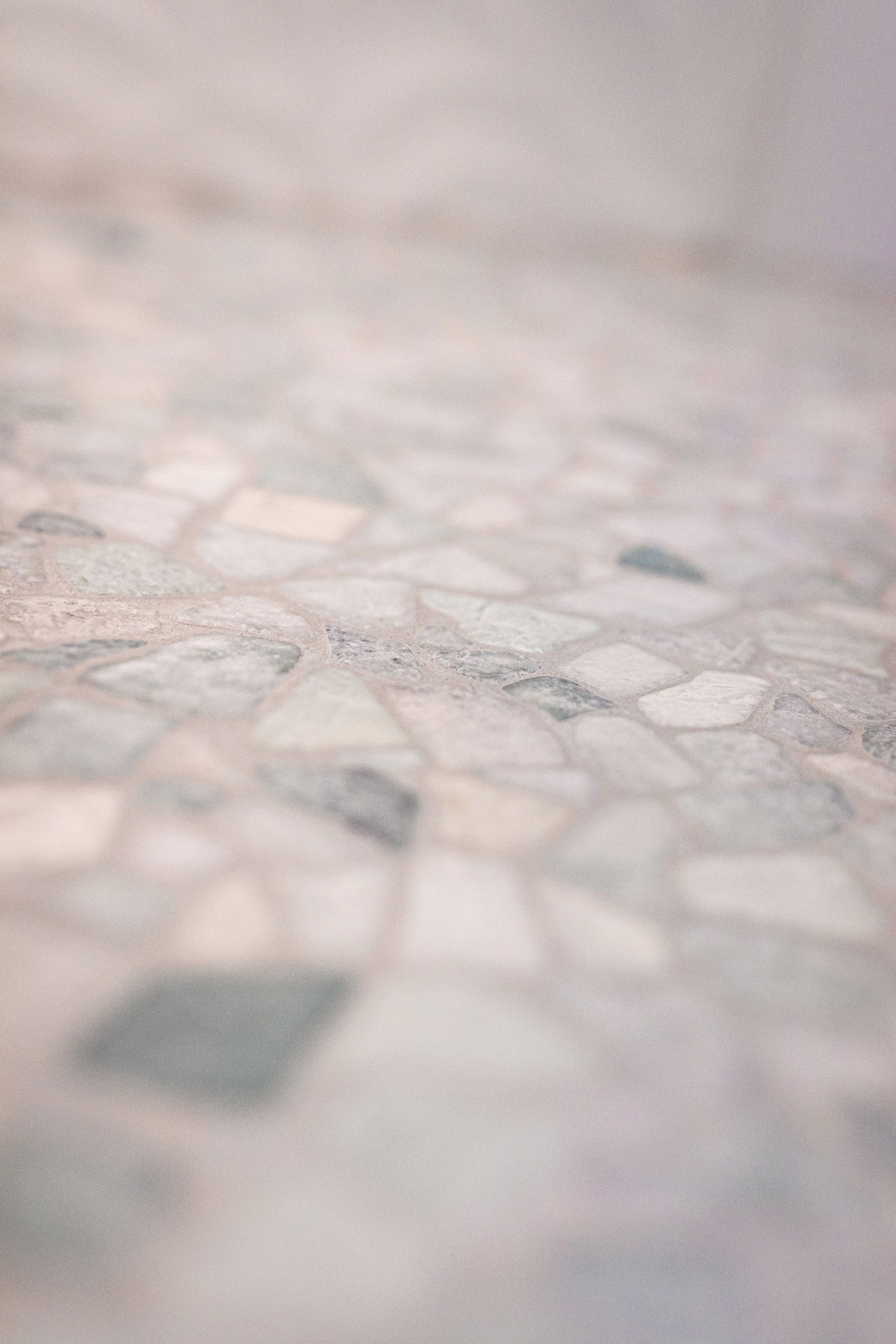 A man is laying tiles on the floor with a trowel.