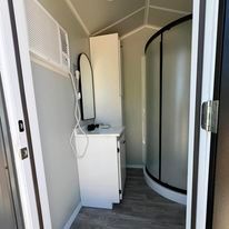 A bathroom with a sink , mirror , and shower.