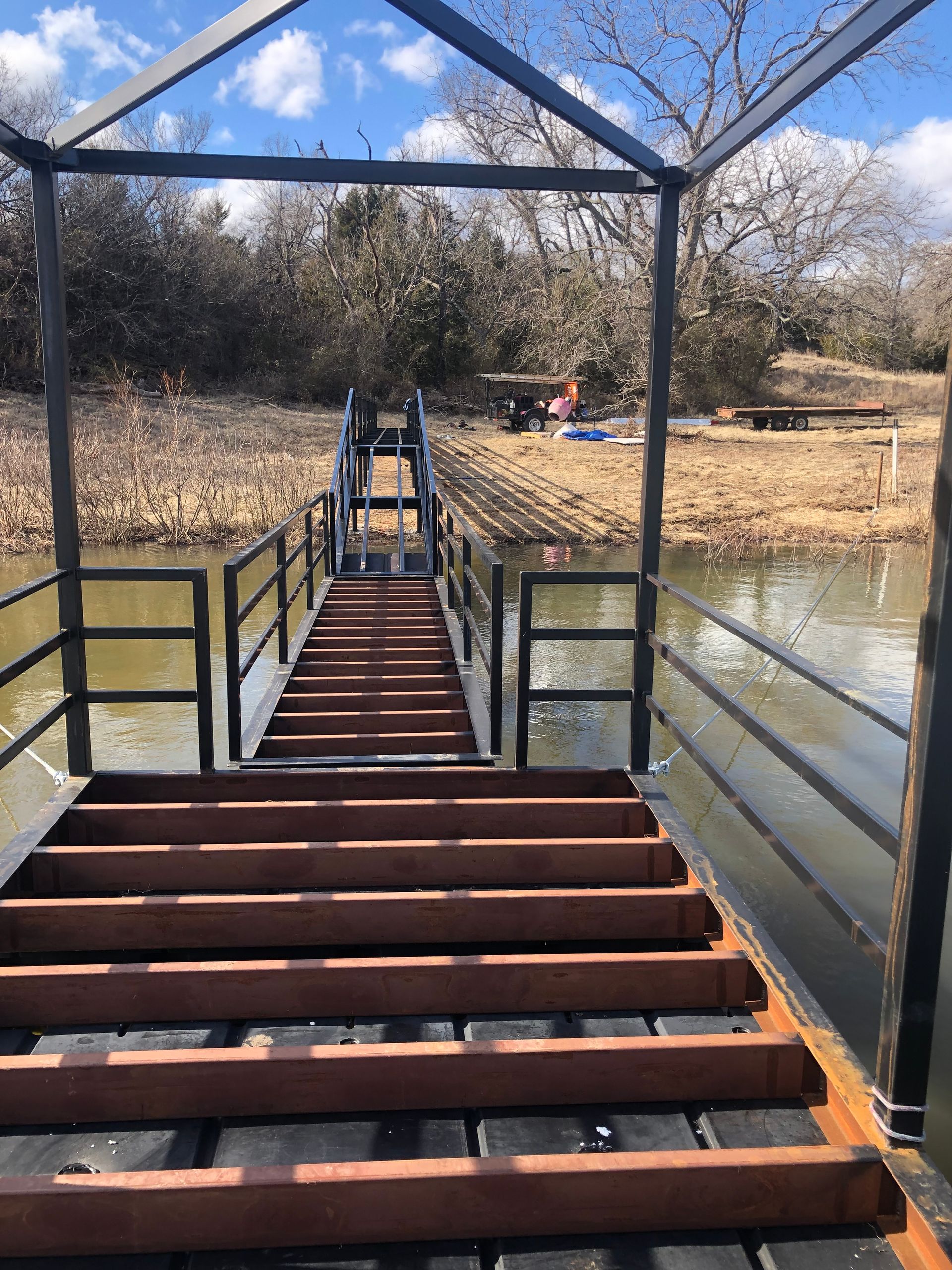 A wooden bridge leading to a body of water.