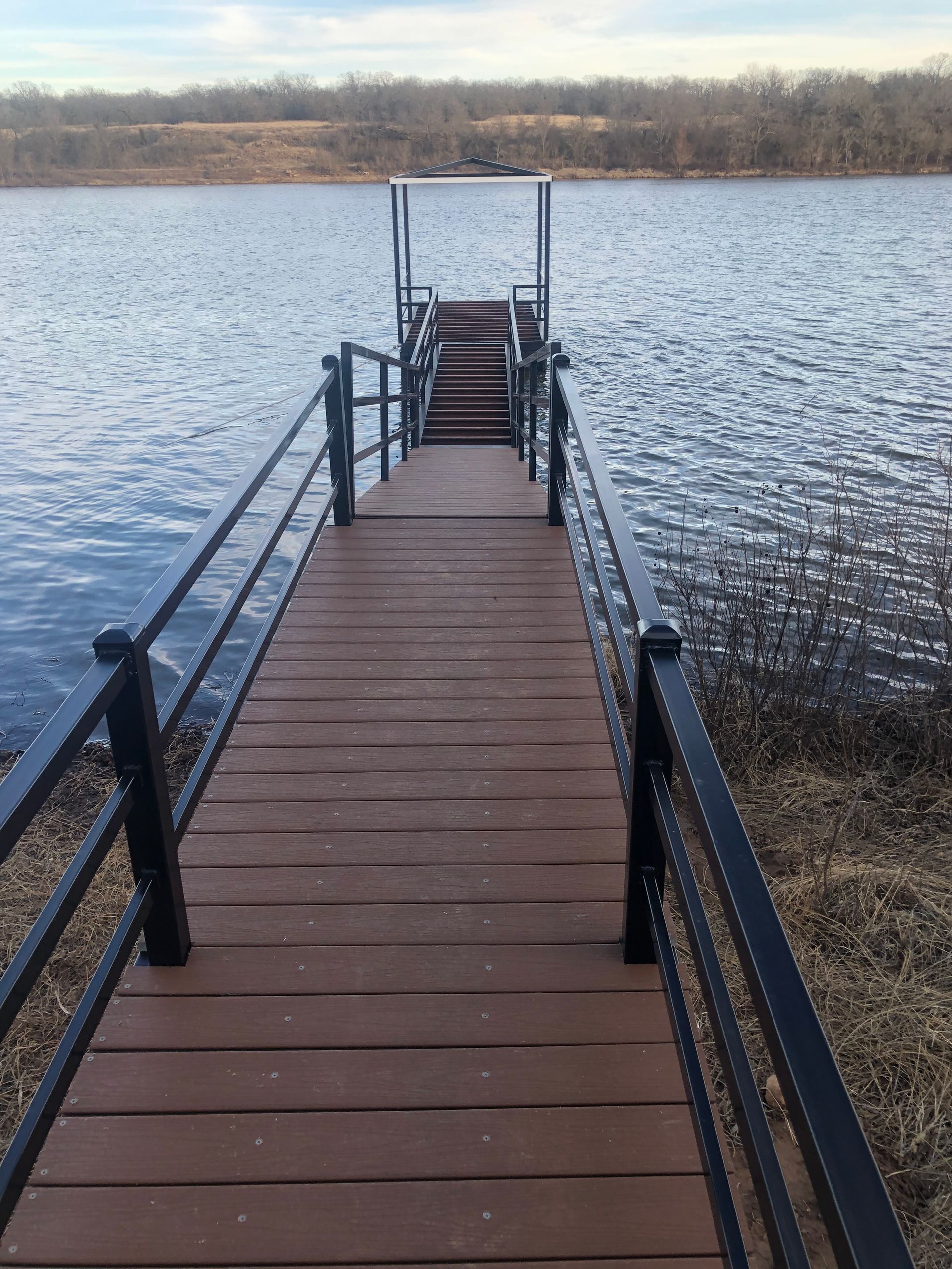 A wooden dock with stairs leading to a lake