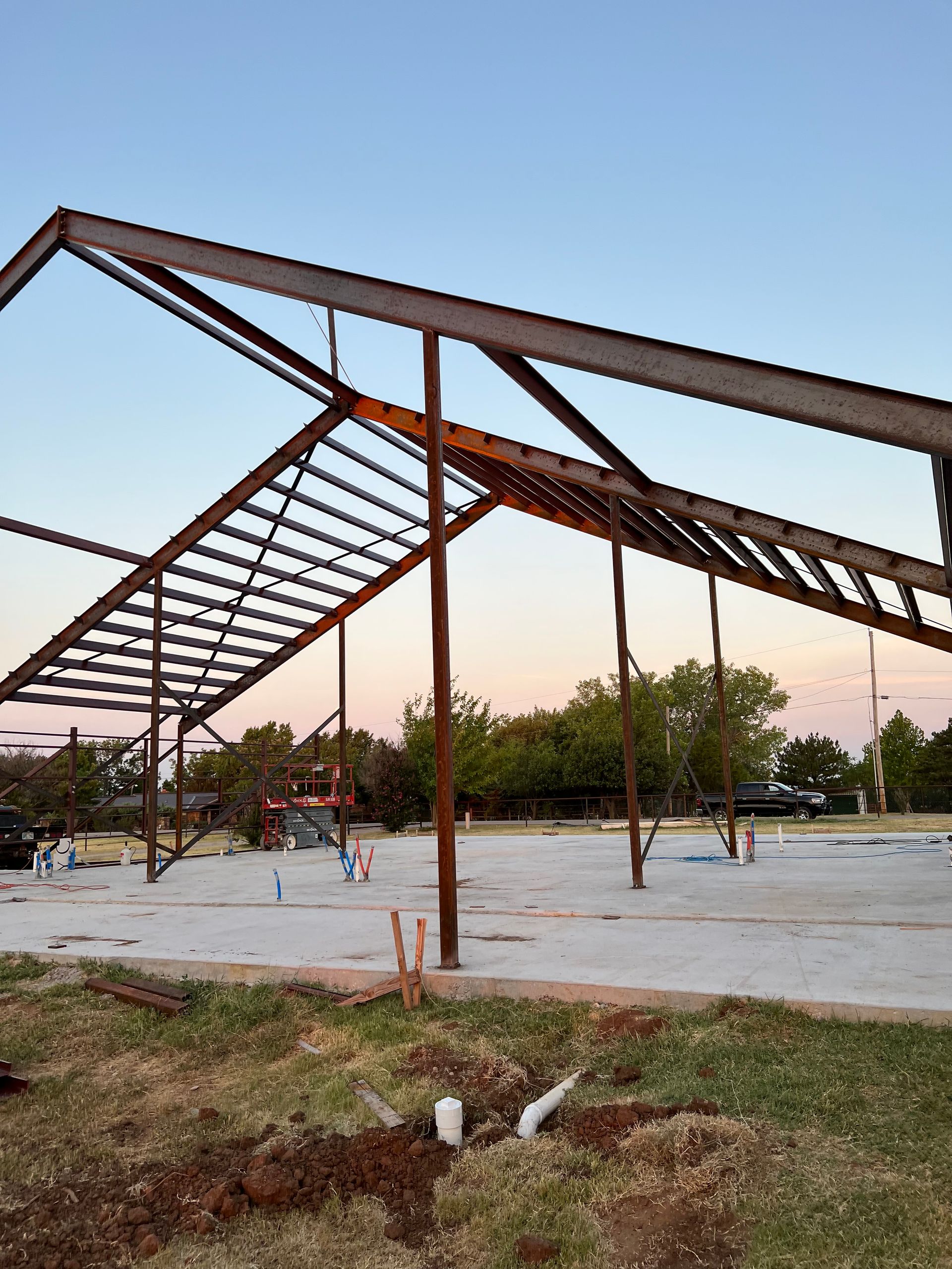 A large metal structure is being built in the middle of a field.