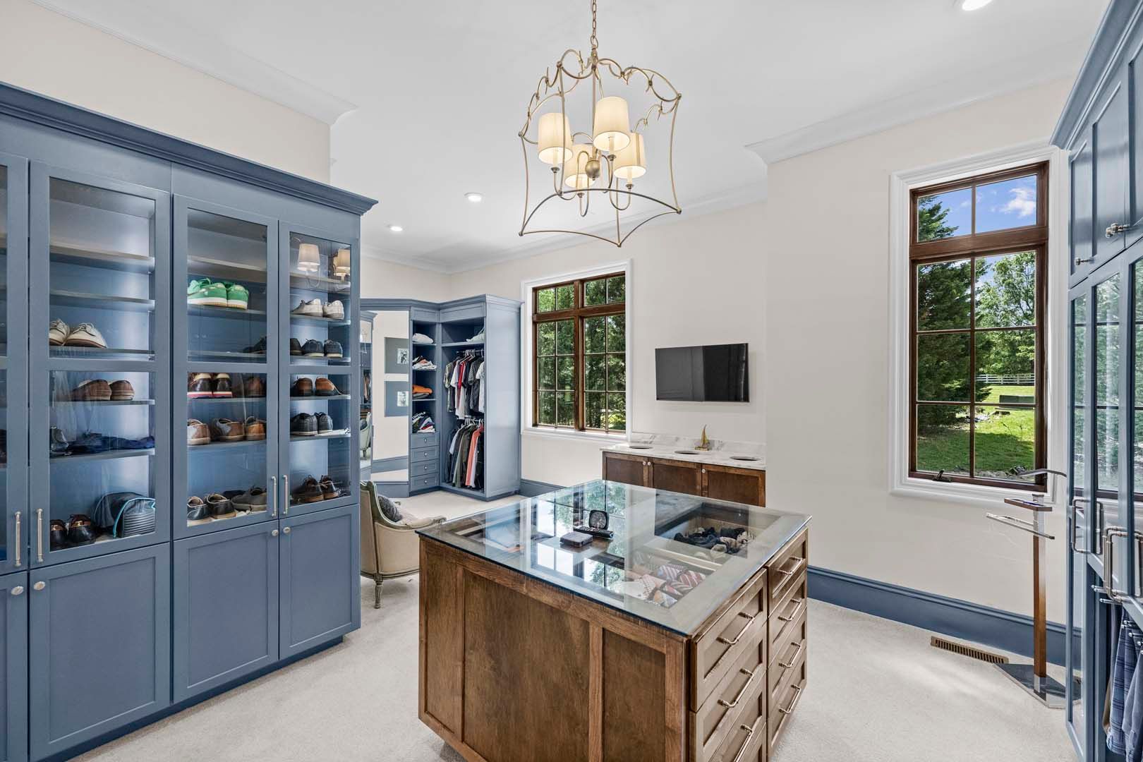A Walk-in Closet With Blue Cabinets And A Large Mirror — Charlotte, NC — Harland Building Group