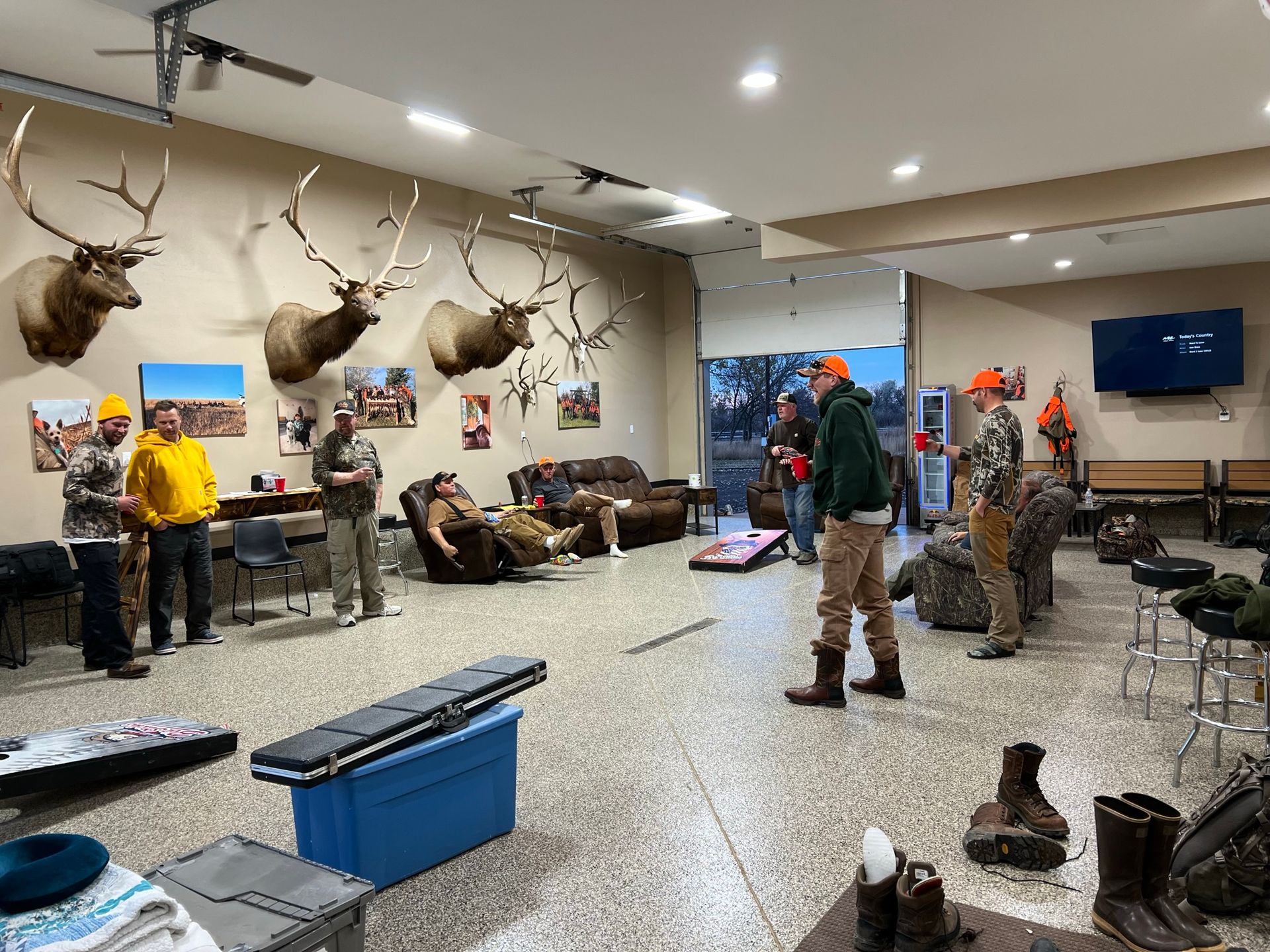 A group of people are standing in a room with deer heads on the walls.