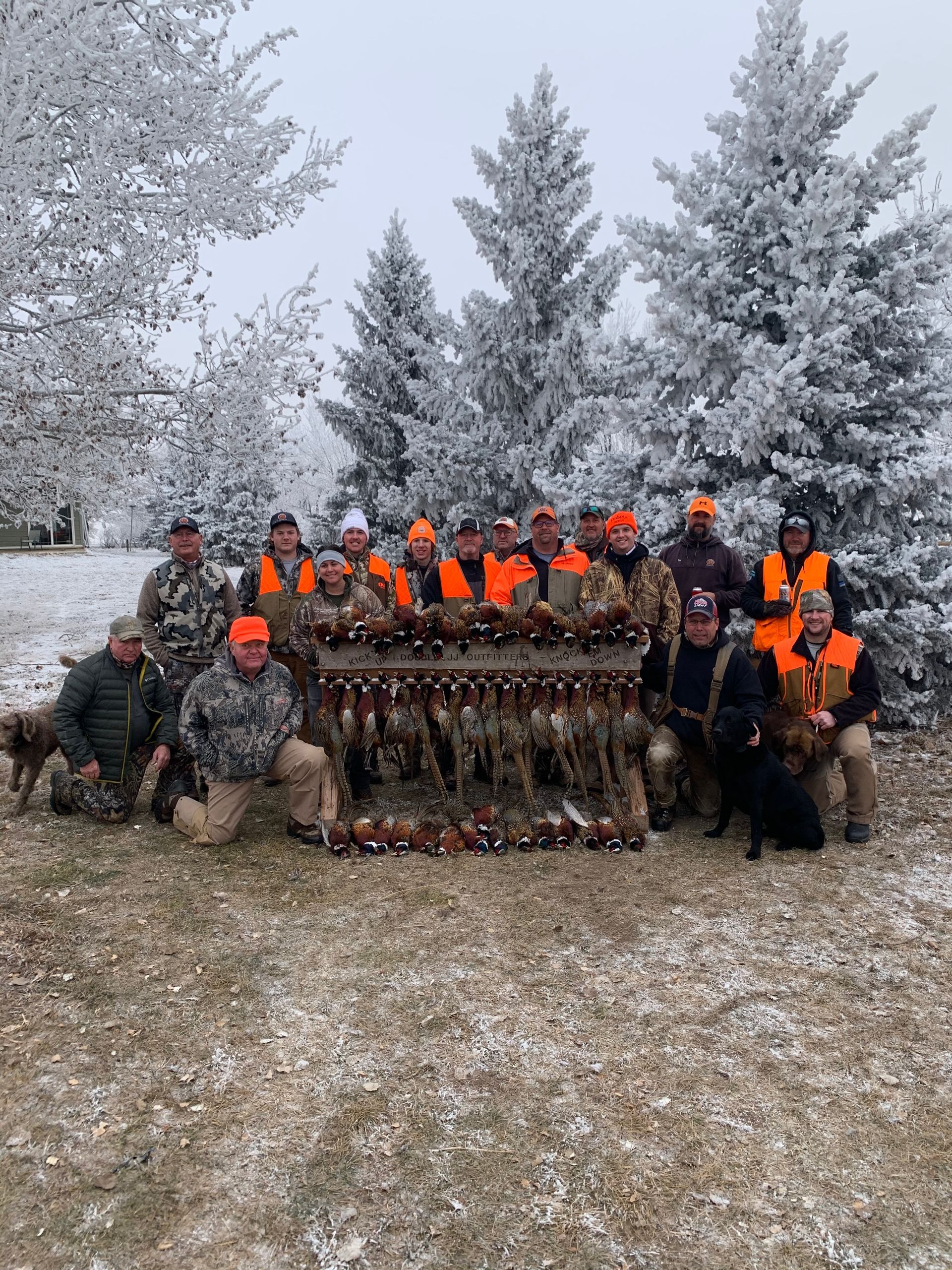 A group of hunters are posing for a picture in the snow.