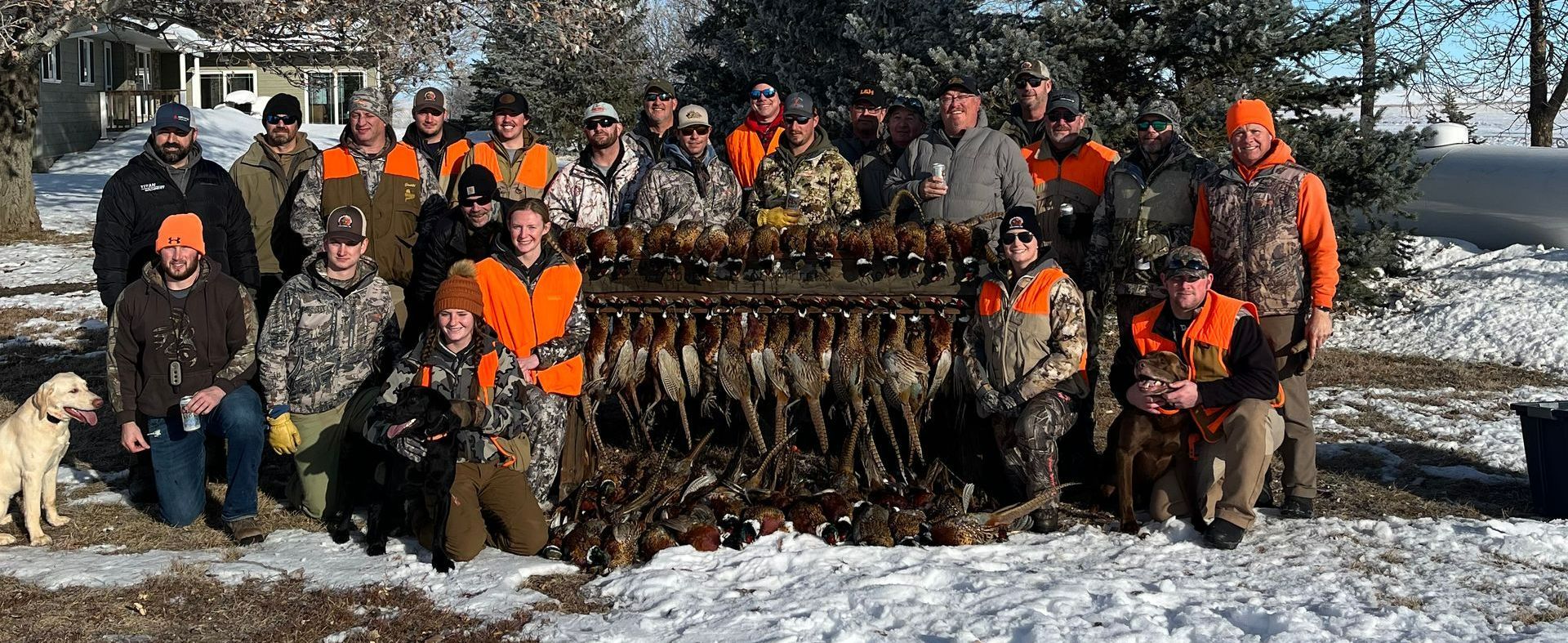 A group of hunters are posing for a picture in the snow.