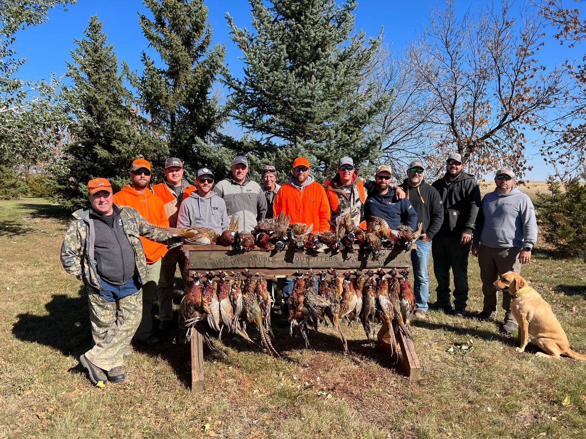 A group of hunters are posing for a picture with their birds.