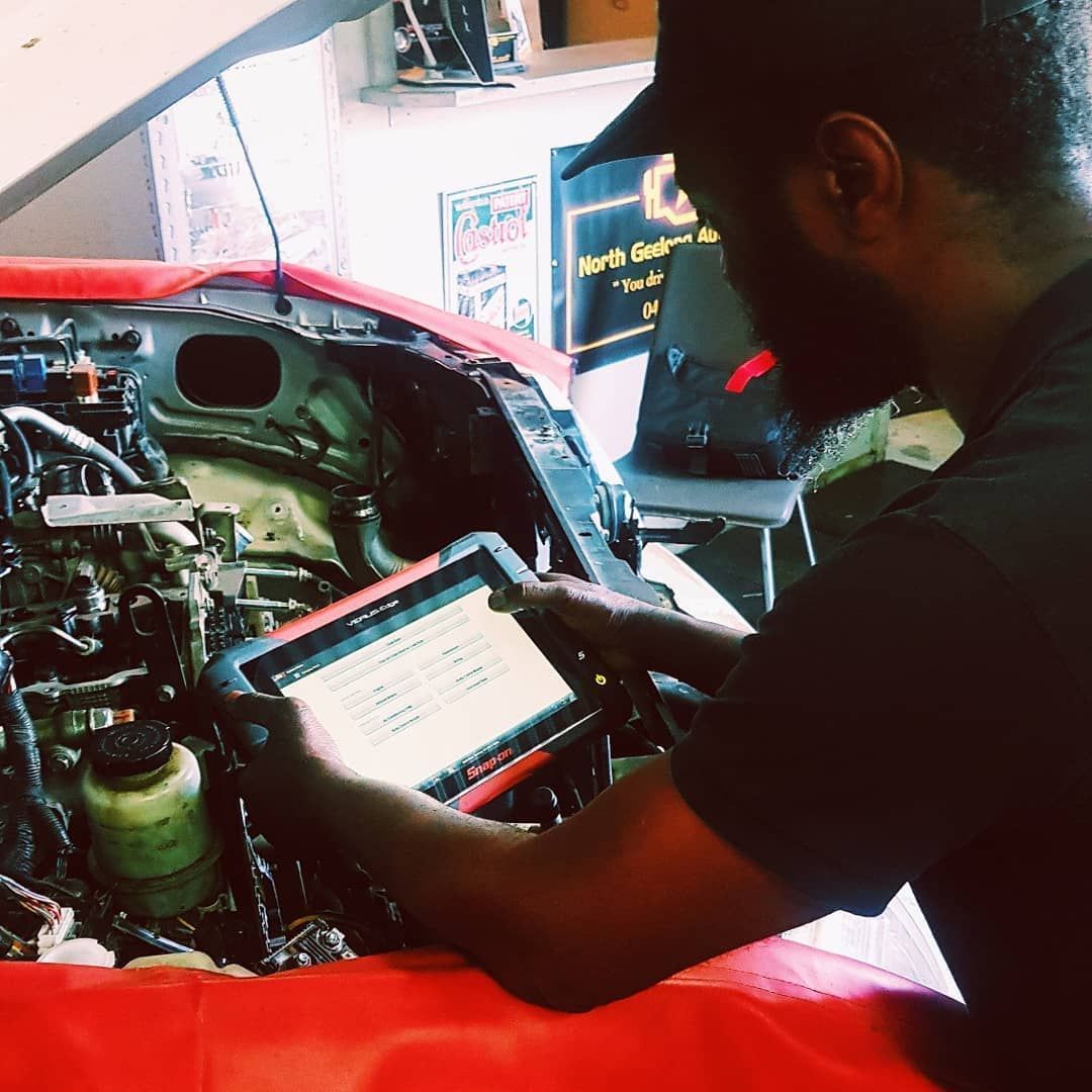 A Man Is Using A Tablet For Diagnosing The Car — North Geelong Automotive In North Geelong, VIC