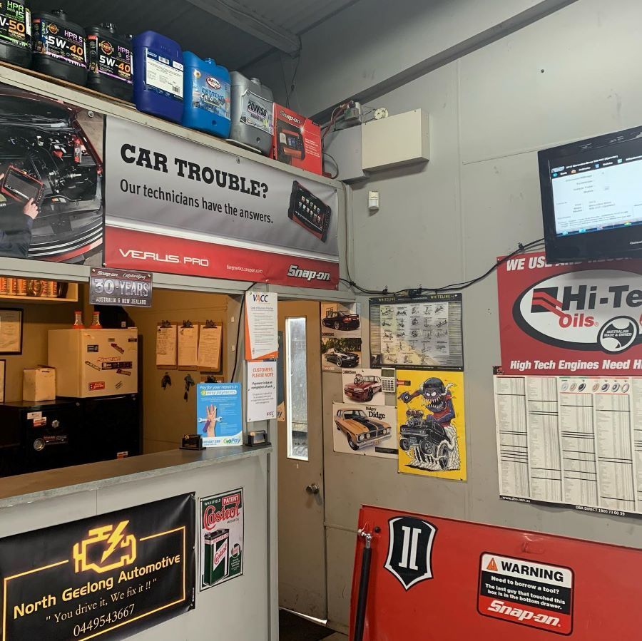 Auto Repair Shop With Oil Shelves, Posters, a Door, and a Monitor — North Geelong Automotive In North Geelong, VIC