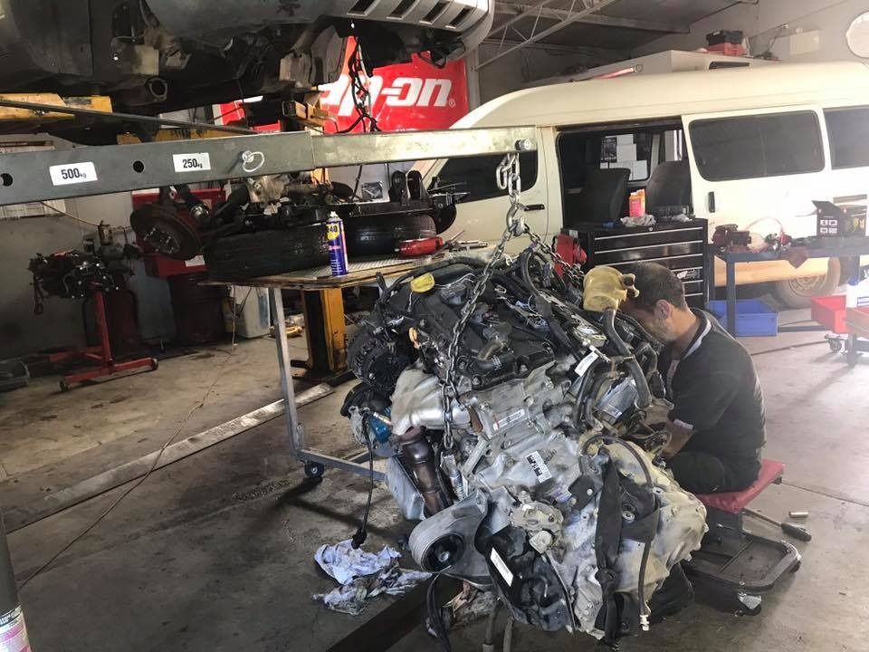 Mechanic Works on a Complex Car Engine