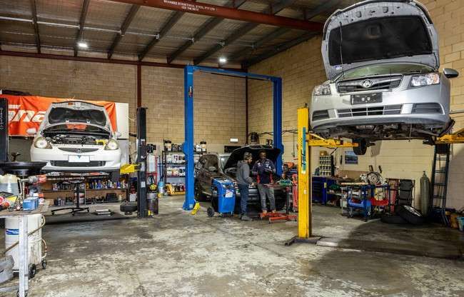 Automotive workshop in Geelong with cars on hoists and mechanics working