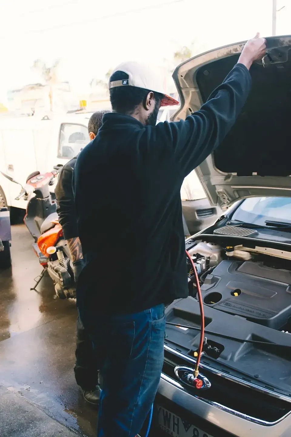 A Man Is Standing Next To A Car With The Hood Open — North Geelong Automotive In North Geelong, VIC