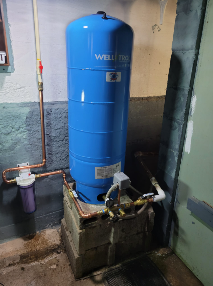 Water well pump tank in basement area