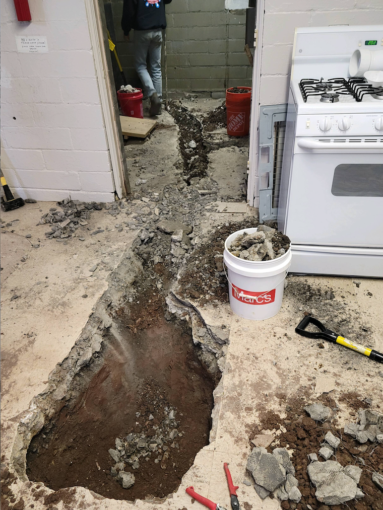 Trench being readied for new sewer line installation.