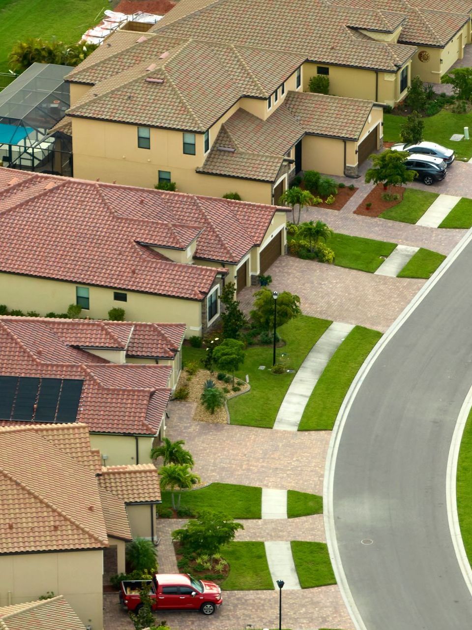 A red van is parked in front of a row of houses