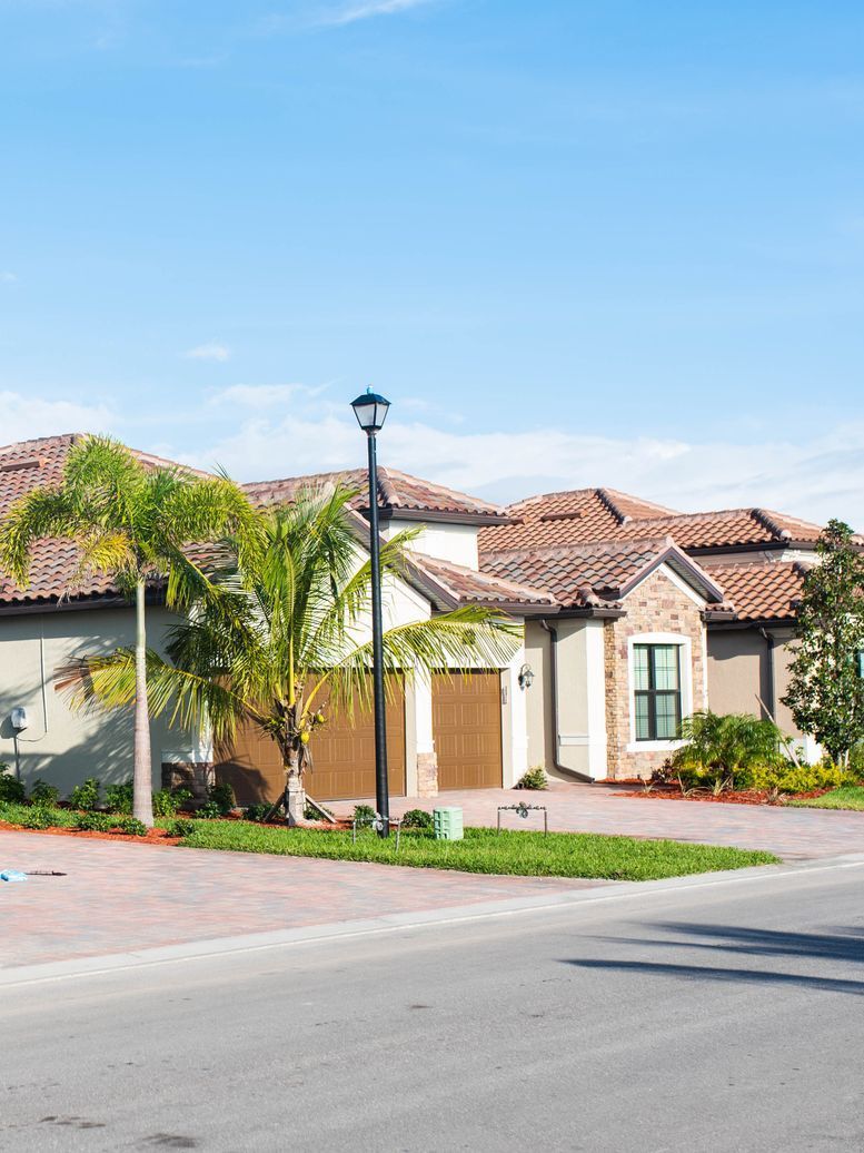 A large house is sitting on the side of the road in a residential neighborhood.