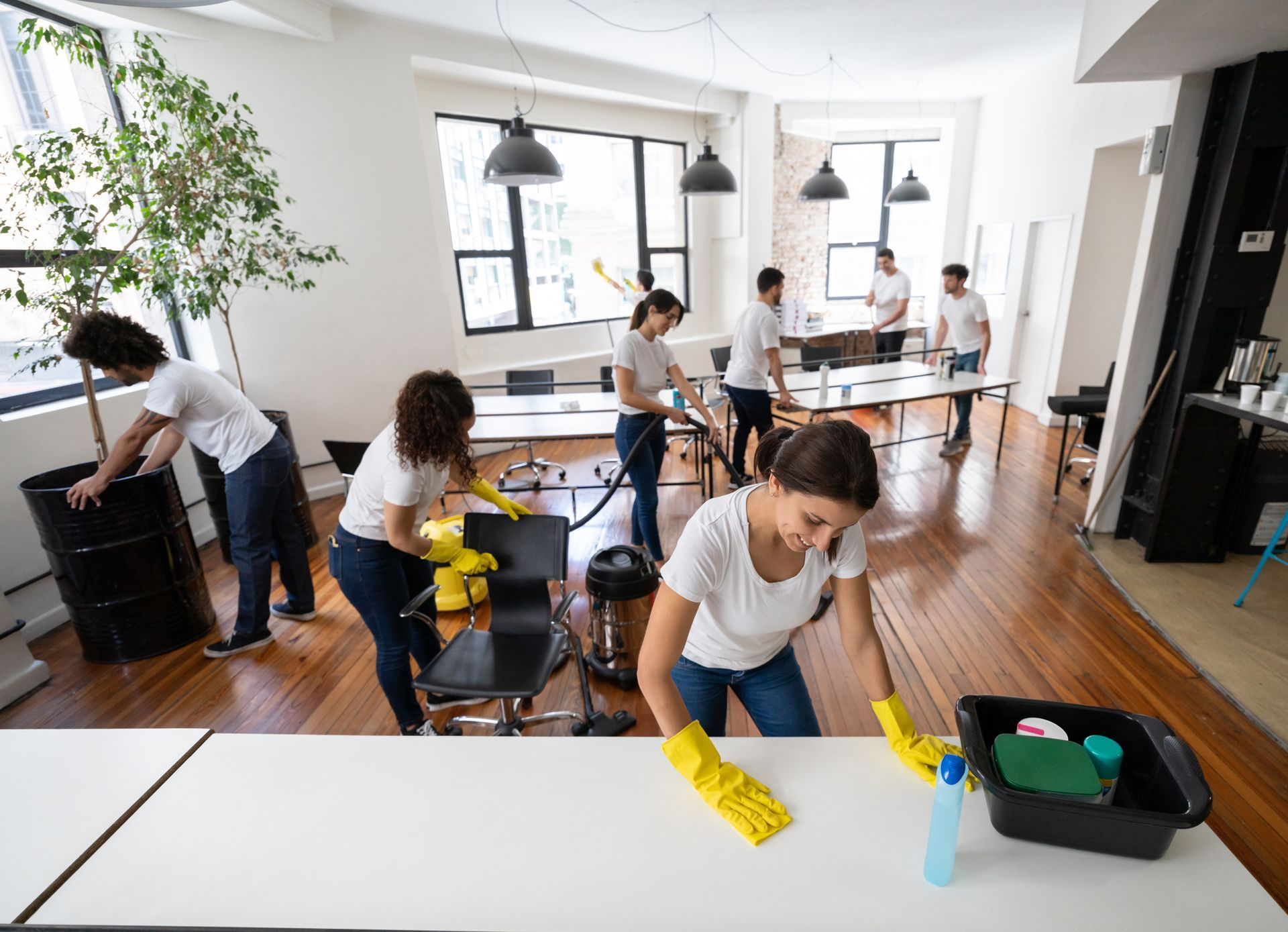 A group of people are cleaning a large office.