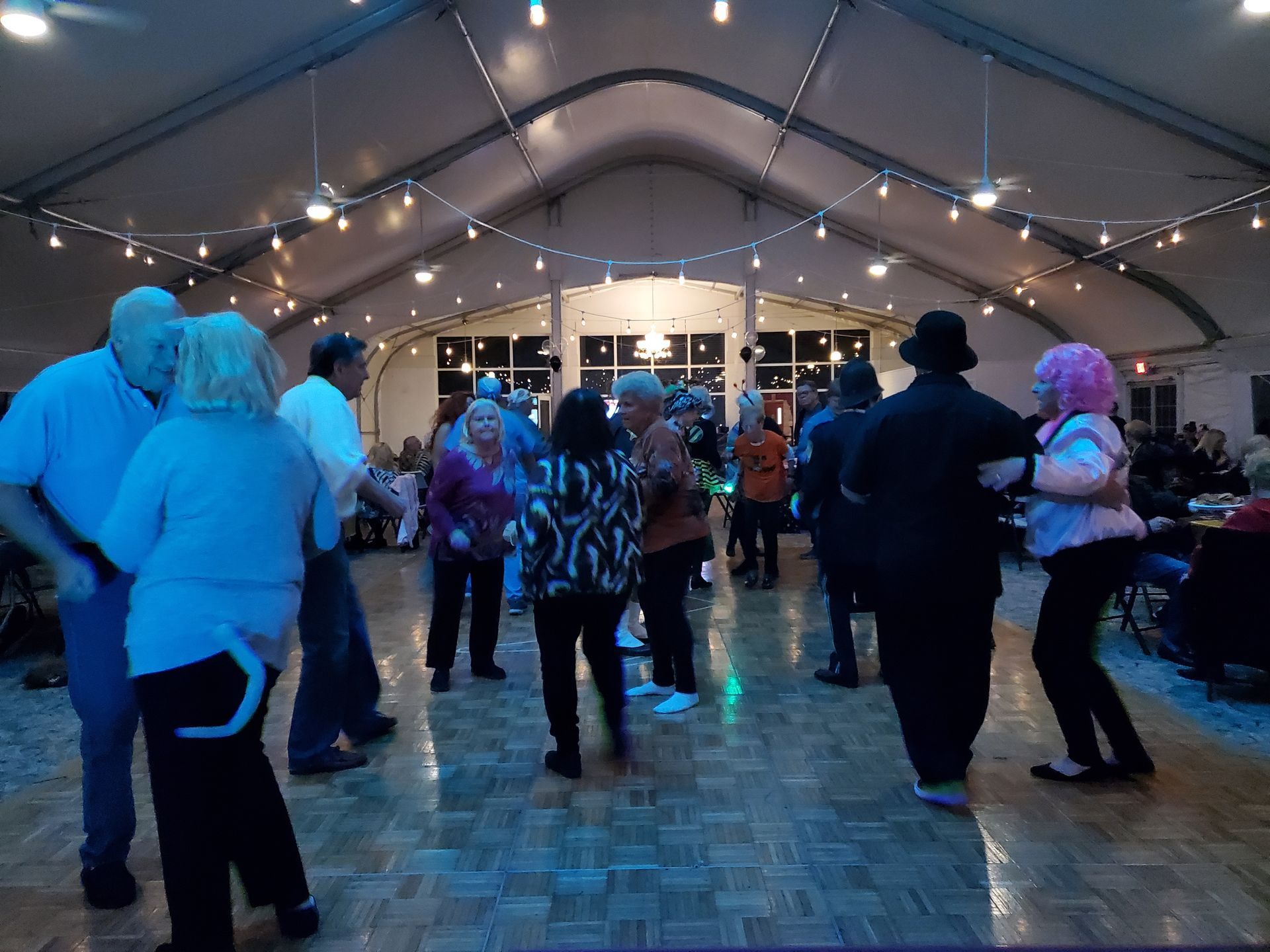 A group of people are dancing in a large room