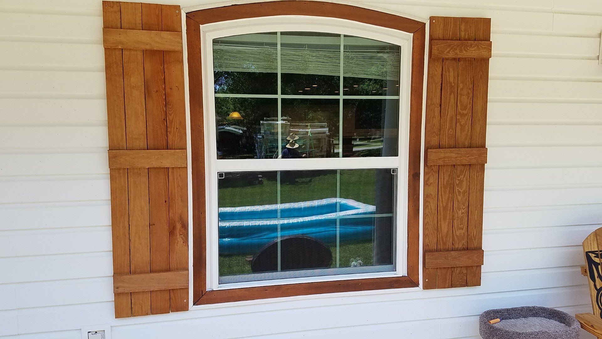 A window with wooden shutters on a white house