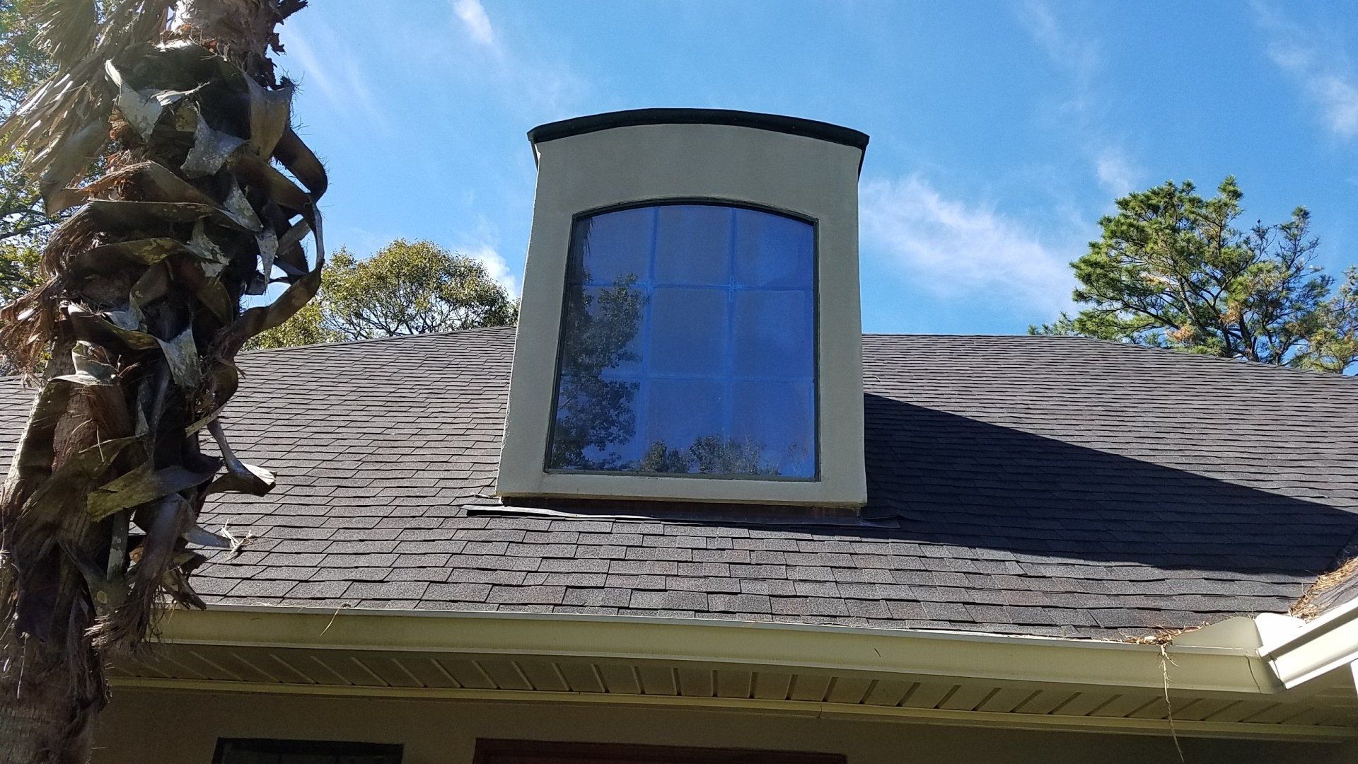There is a window on the roof of a house.