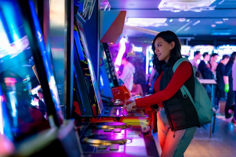 A woman is playing a video game in an arcade.