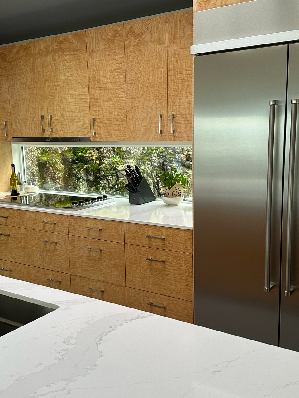 A kitchen with stainless steel appliances and wooden cabinets.