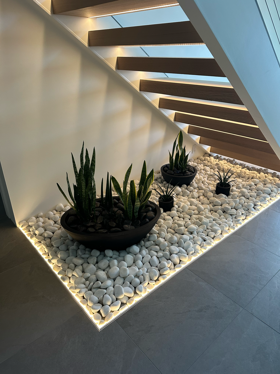 A staircase with plants and rocks underneath it