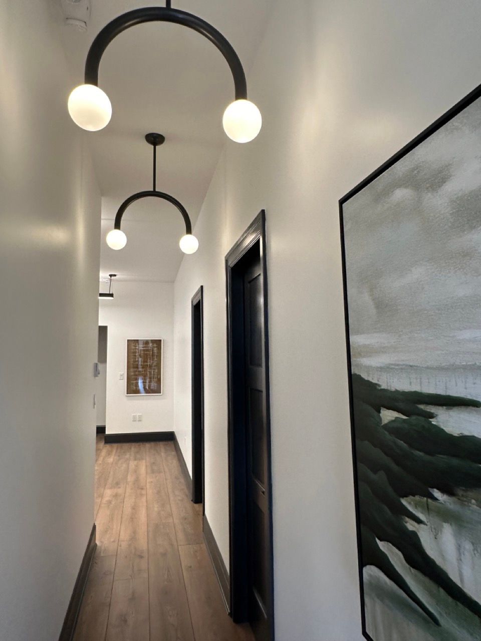 A long hallway with a painting on the wall