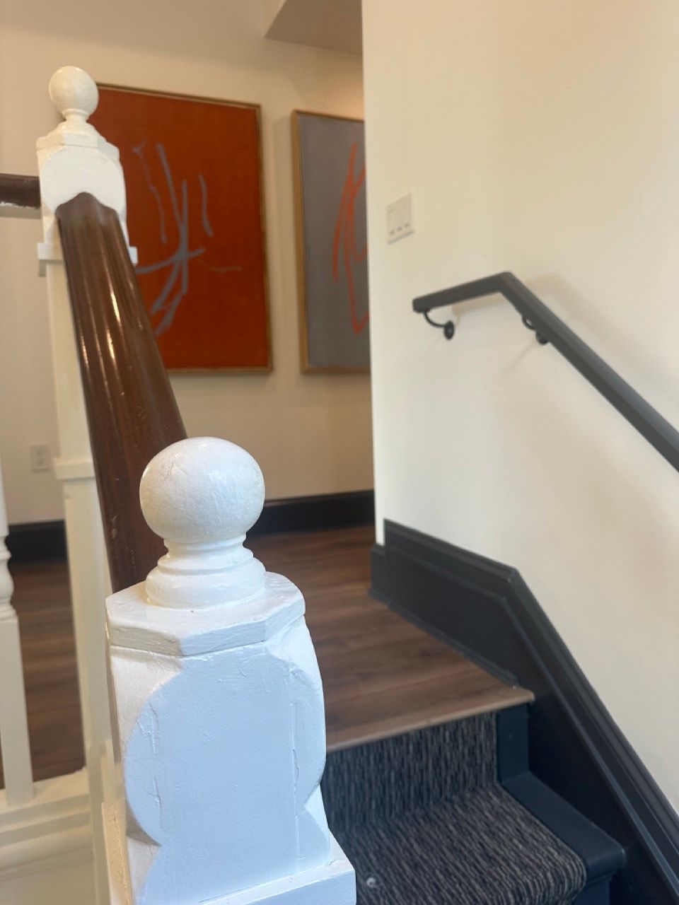A staircase with a white railing and a black handrail