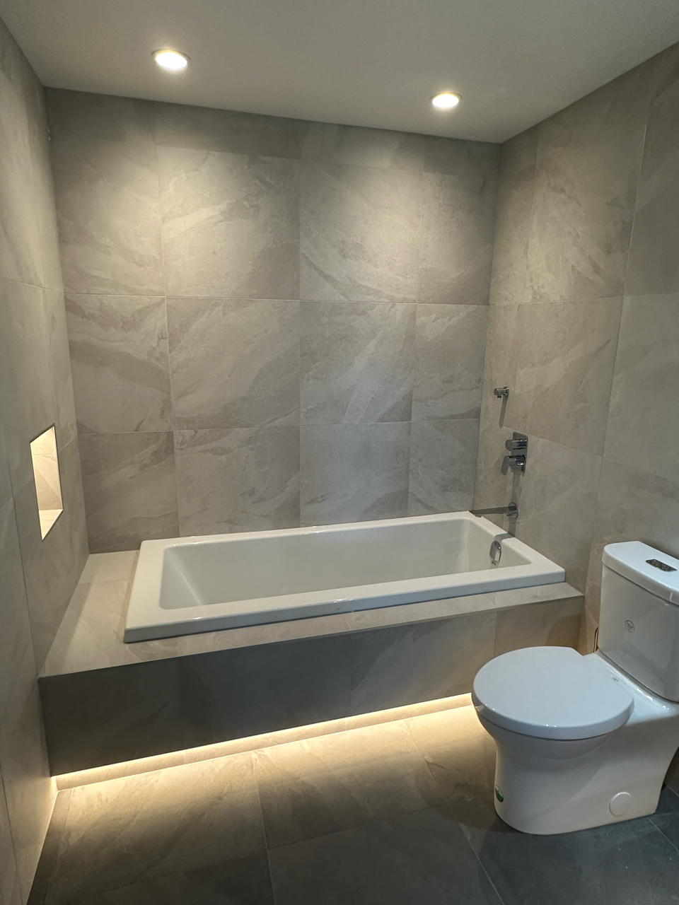 A bathroom with a bathtub , toilet and shower.