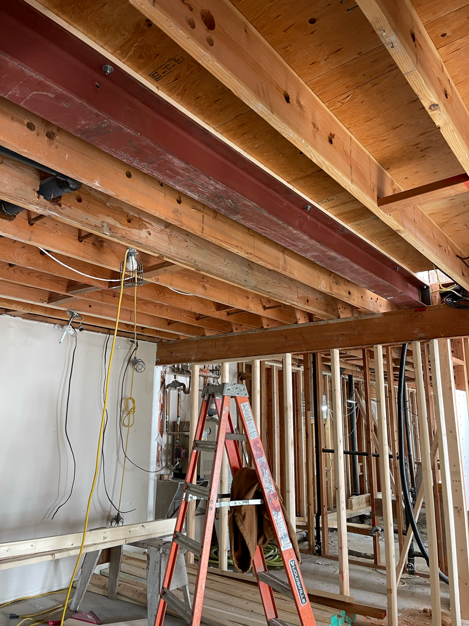 A ladder is sitting in the middle of a room under construction.