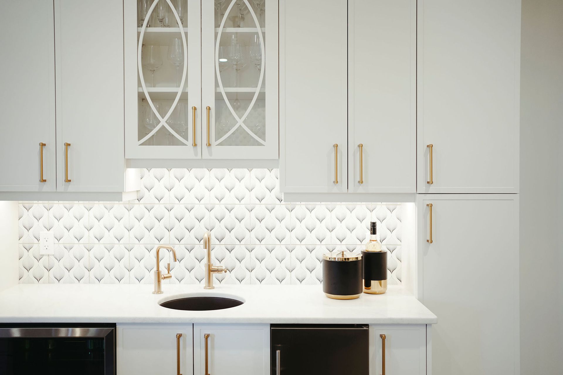 A kitchen with white cabinets , a sink , and a refrigerator.
