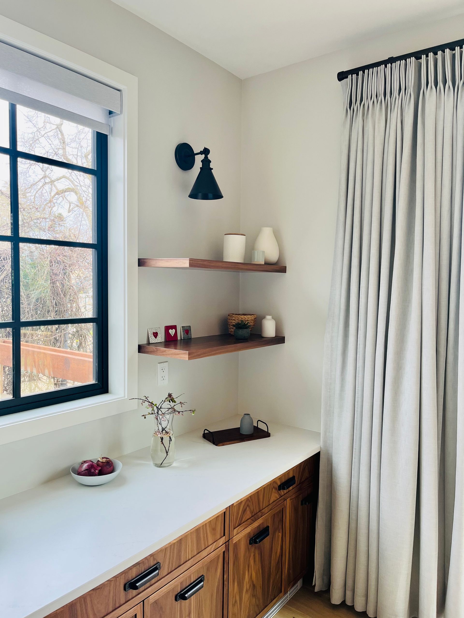 A kitchen with a sink , cabinets , shelves and a window.