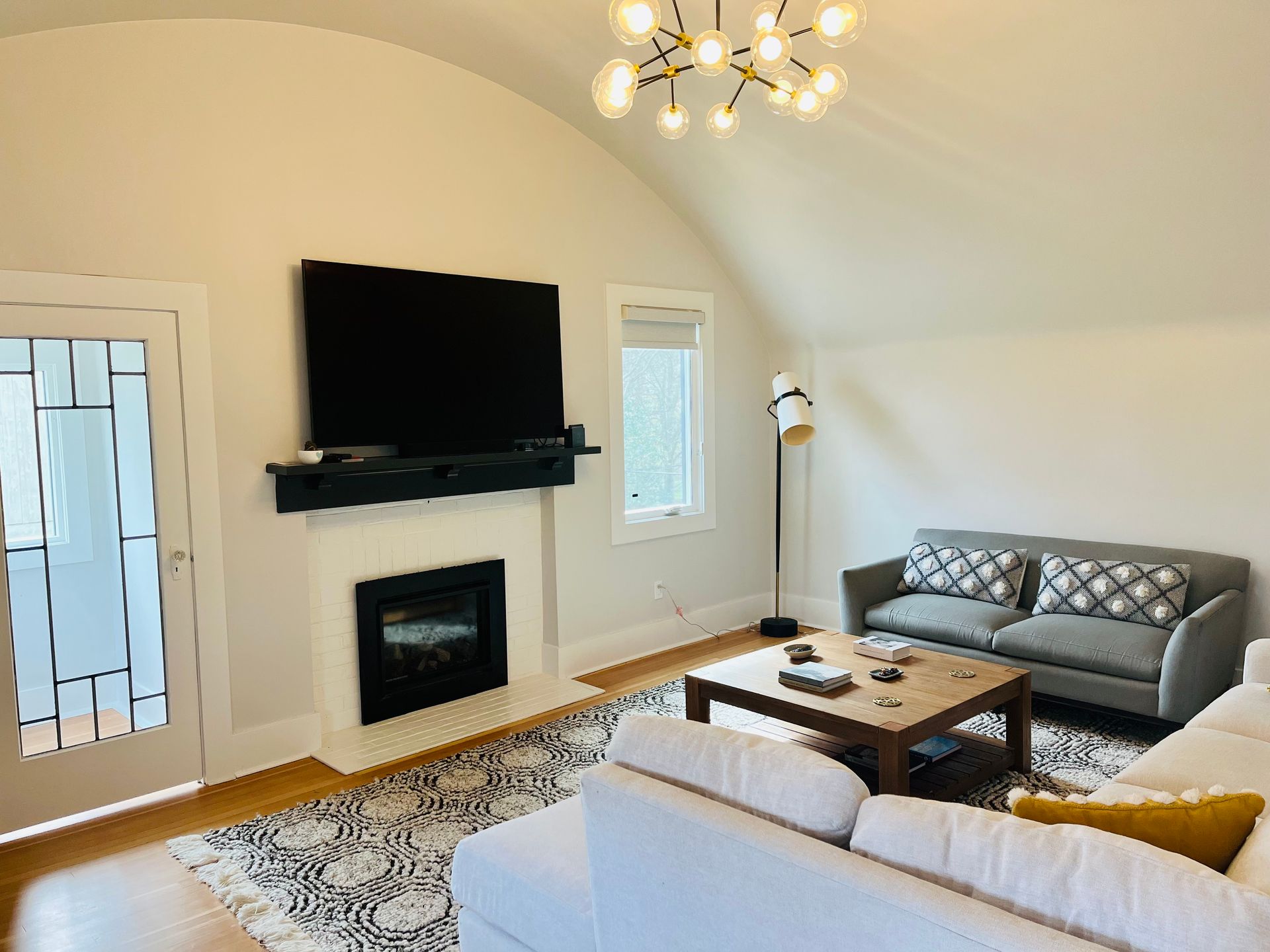 A living room with a couch , fireplace and television.