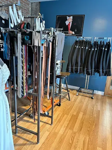 Inside a clothing store: belts, suit jackets, and a 