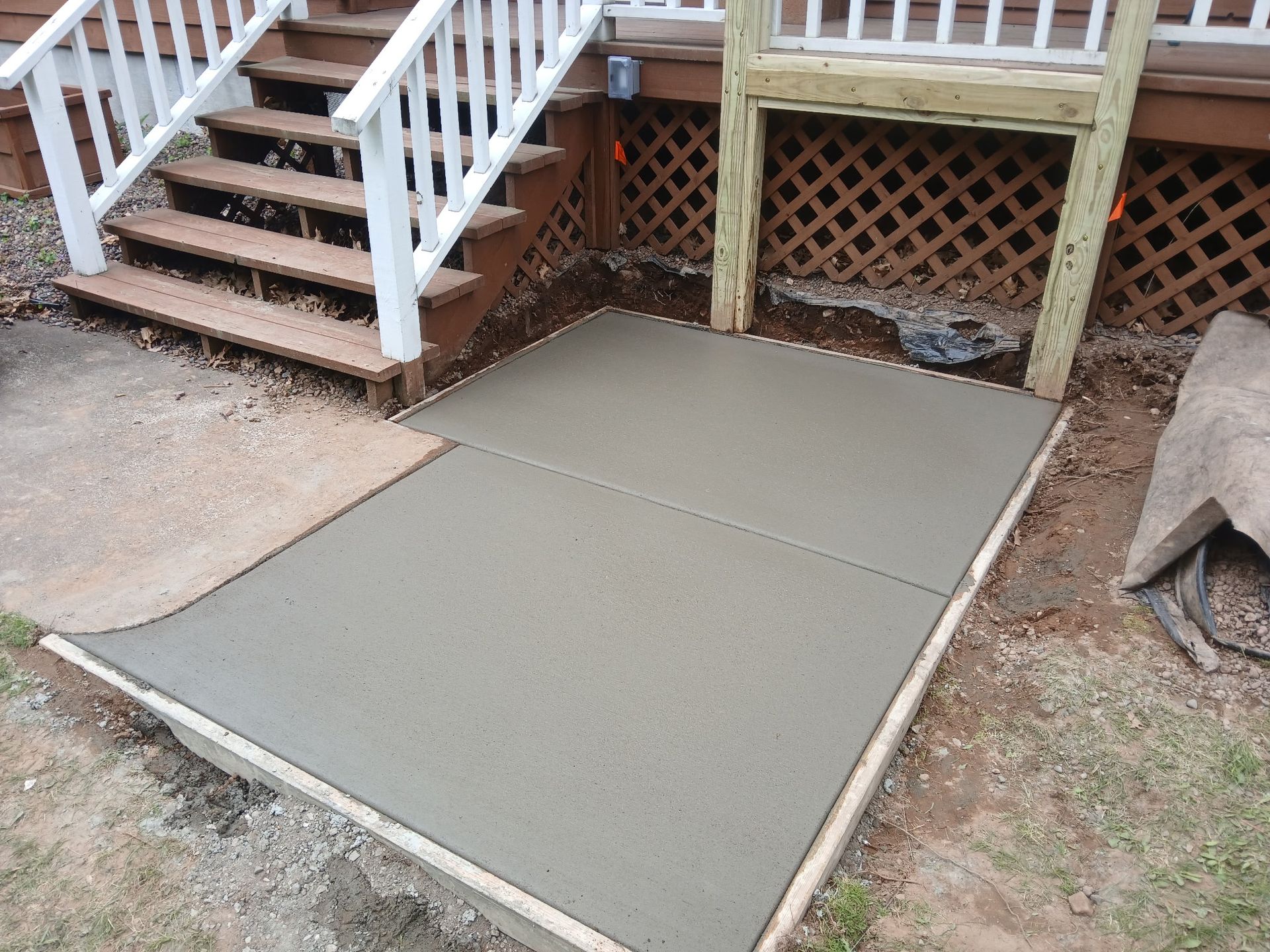 A concrete walkway is being built in front of a house