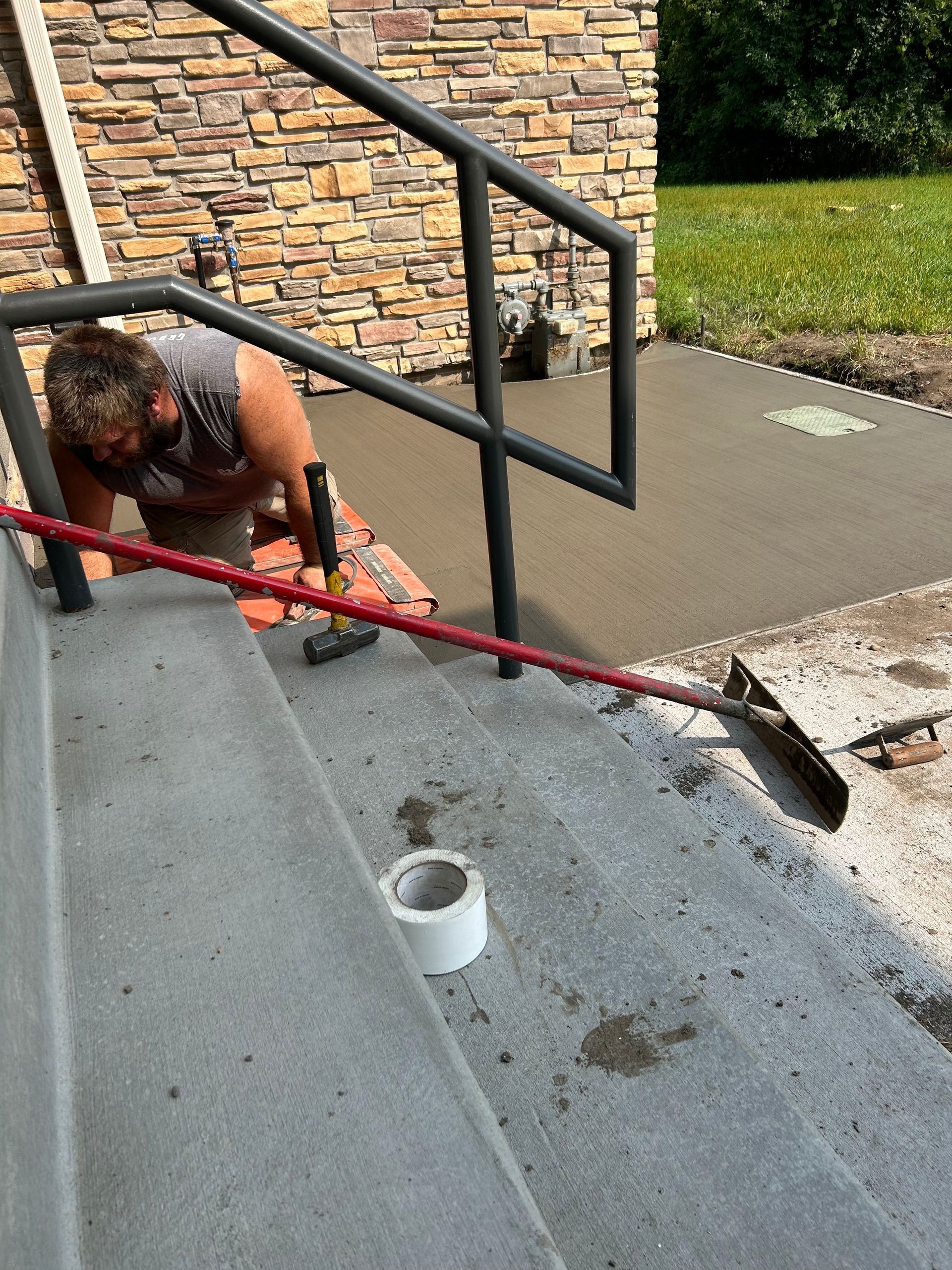 A man is working on a set of stairs with a rake.