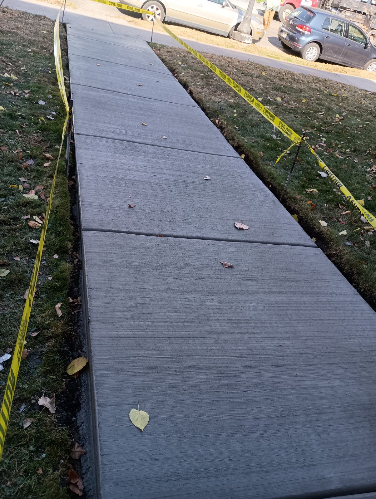 A concrete walkway with a car parked on the side of it.