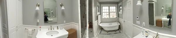 Bathroom with a pedestal sink, a free-standing bathtub, and a window. Light gray walls.